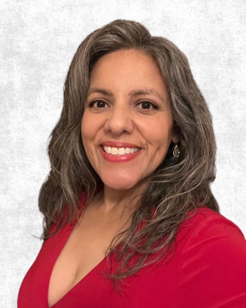 Coach Melina smiling in a festive red dress with a gray textured background