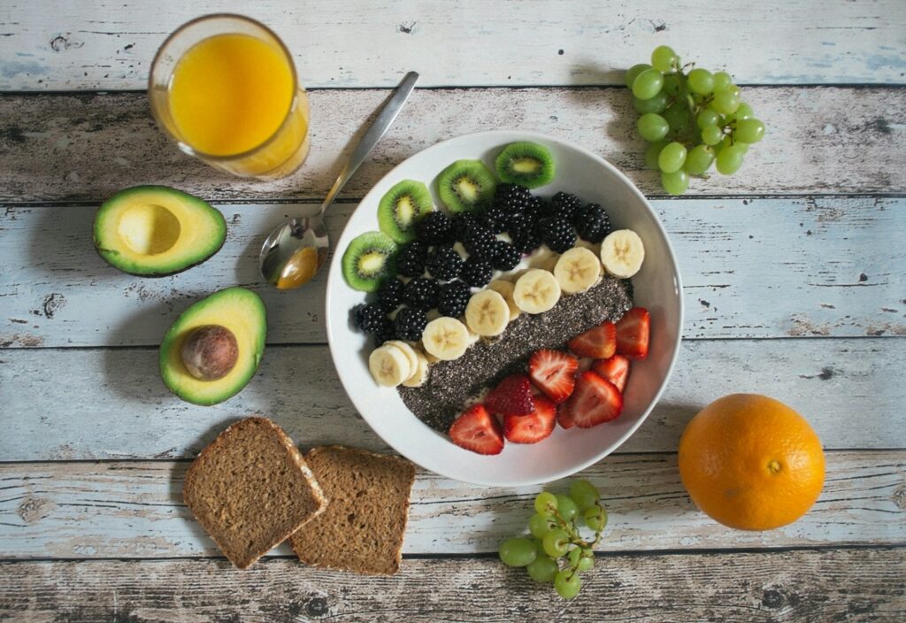 Bowl of fruits with bread, and veggies around it